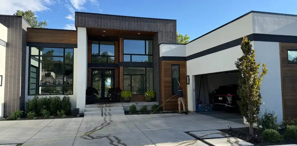 Canyon Clear technician cleaning a tall residential window