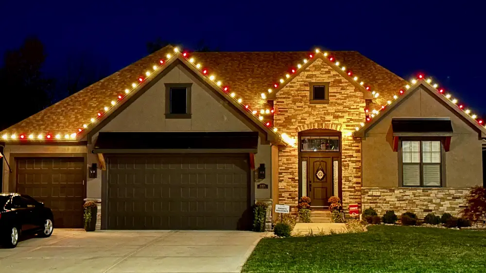 Utah County home with warm-white and red Canyon Clear holiday lights along the rooflines at dusk
